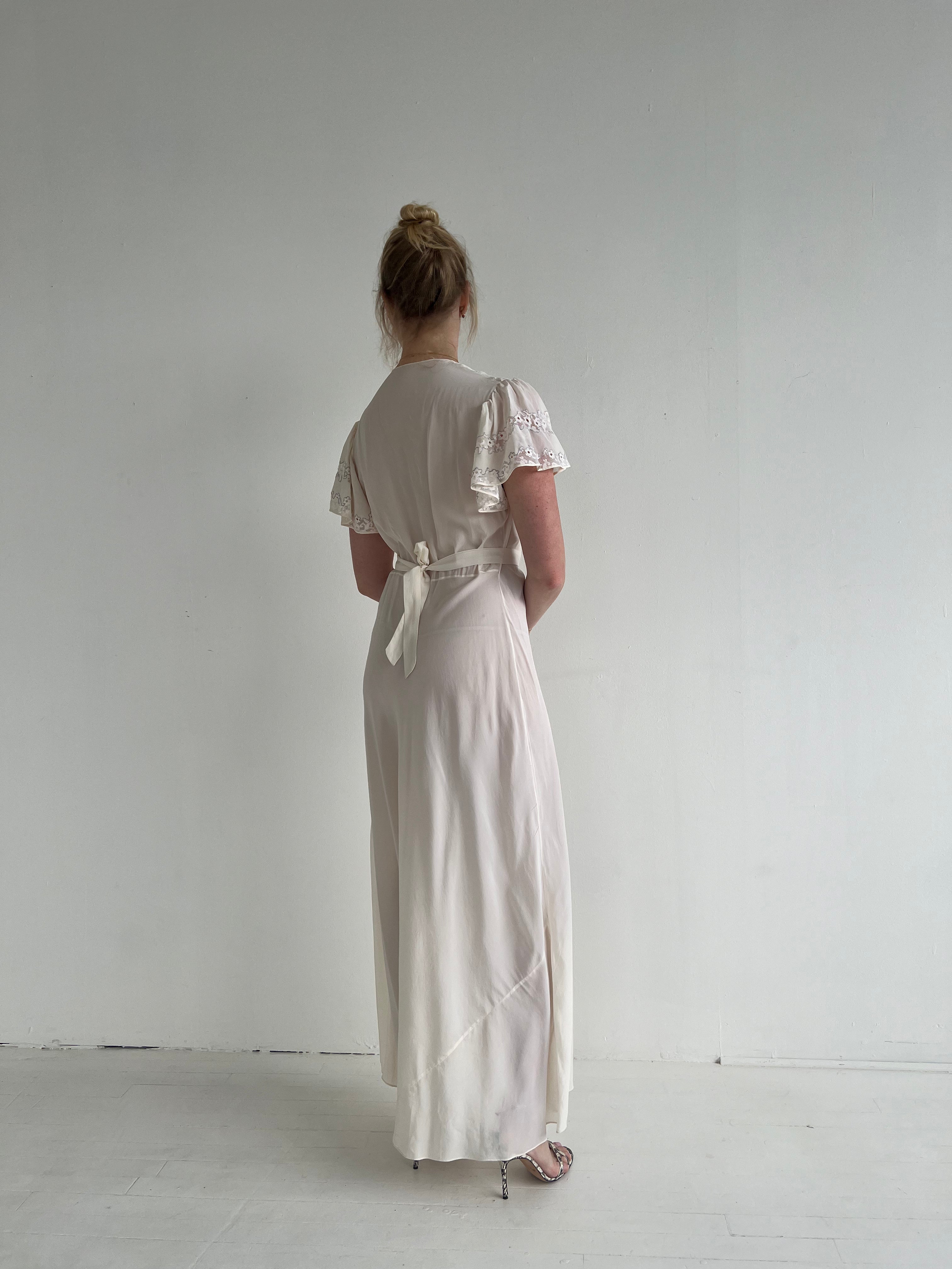 white silk dress dyed with tiger butterflies and waves detail A white dress transformed through the ancient art of tiedye: butterflies shaped with clamps, fabric folded and bound, dipped again and again in indigo and rinsed until patterns emerge. The result is